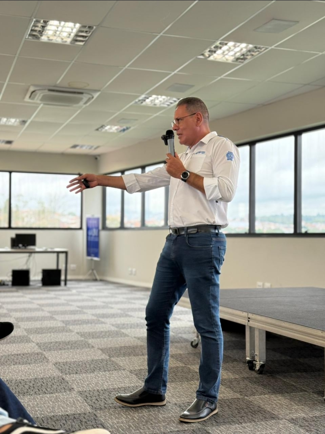 Robinson Abbade palestrando com microfone em um evento